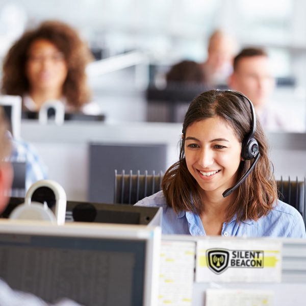 Young woman working in call centre, surrounded by colleagues